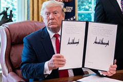 President Trump holding up document with signature on Executive Order on Iran sanctions