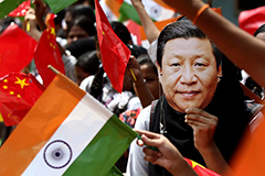 Indian schoolgirl wears a face mask of Chinese President Xi Jinping