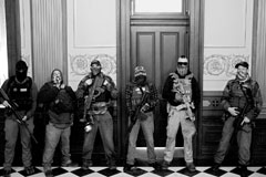 Members of a militia group outside the office of Michigan governor Gretchen Whitmer during a protest against her Covid stay-at-home order, Lansing, April 30, 2020. Three of them were later charged with being involved in a plot to kidnap her, attack the state capitol building, and incite violence.