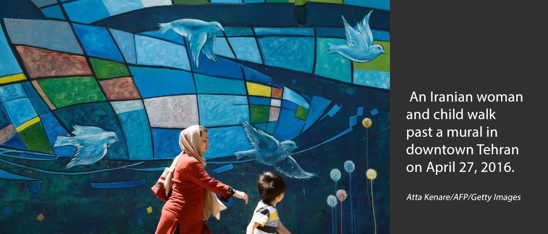 An Iranian woman and child walk past a mural in downtown Tehran on April 27, 2016. Atta Kenare/AFP/Getty Images