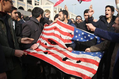  Iranians tear up a US flag during a demonstration in Tehran on January 3, 2020.