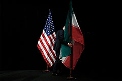 US and Iran flags with defeated person walking between them