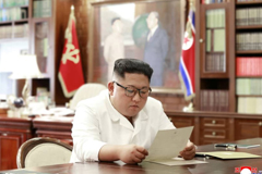 North Korean leader Kim Jong Un reads a letter from U.S. President Donald Trump in Pyongyang in this picture released Sunday. | REUTERS