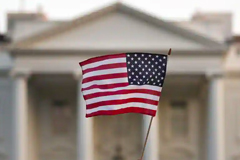 White House with US flag waving in front of it