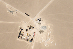 Chinese engineers erected an inflatable dome over the construction site of an underground missile silo, left, to hide the work below. Support facilities and temporary storage for construction equipment are seen at right.Credit...Planet Labs Inc.