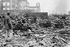 A photo of a man looking at a destroyed Hiroshima