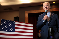 Biden speaking with American Flag backdrop