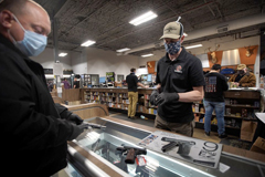 Cape Gun Works co-owner Toby Leary helped a customer in May. The demand for guns skyrocketed in 2020, with background checks jumping nearly 24 percent in Massachusetts.BARRY CHIN/GLOBE STAFF